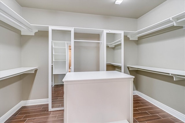 spacious closet with dark hardwood / wood-style flooring