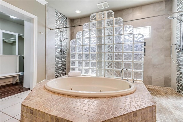 113 Bay Ct, Aransas Pass, TX 78336 - bathroom featuring a whirlpool tub, walk in shower, tile patterned flooring, and a closet