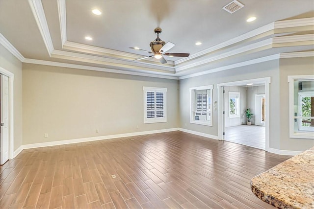 113 Bay Ct, Aransas Pass, TX 78336 - unfurnished room featuring a ceiling fan, a tray ceiling, wood finished floors, ornamental molding, and baseboards