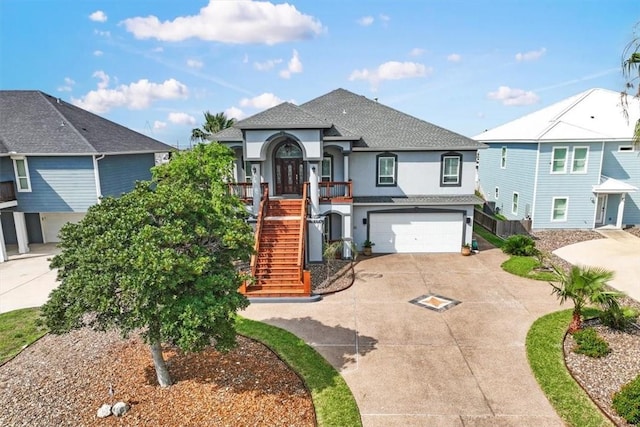113 Bay Ct, Aransas Pass, TX 78336 - view of front of home featuring stucco siding, stairway, driveway, an attached garage, and roof with shingles