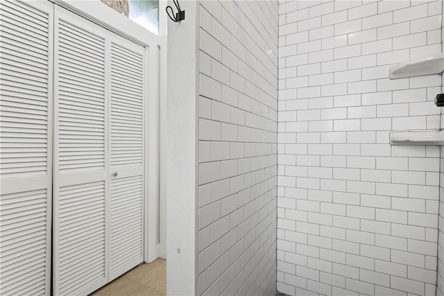 bathroom with tile patterned flooring and tiled shower