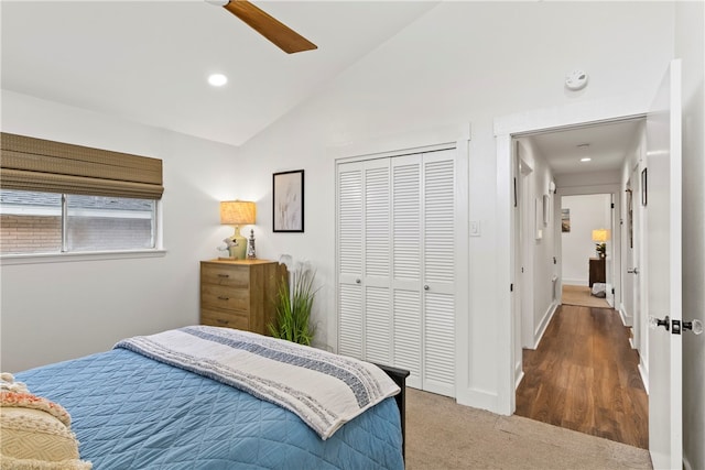 bedroom featuring dark wood-type flooring, ceiling fan, a closet, and lofted ceiling