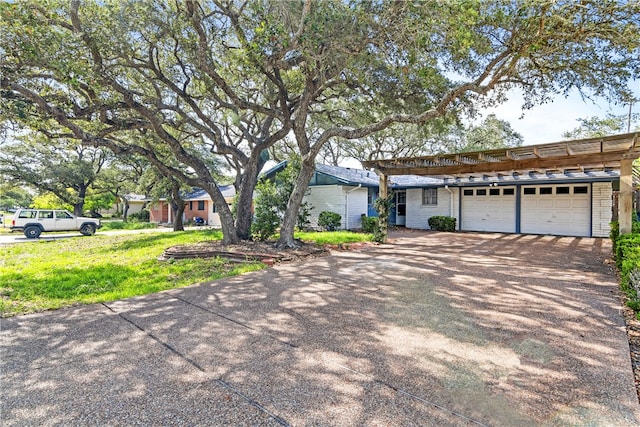 ranch-style home featuring a garage and a front lawn