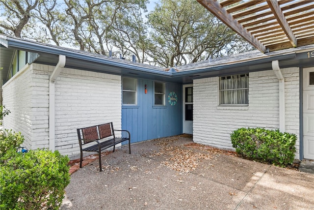 entrance to property featuring a pergola and a patio