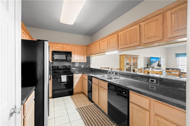 kitchen with light tile patterned floors, sink, dark stone countertops, and black appliances