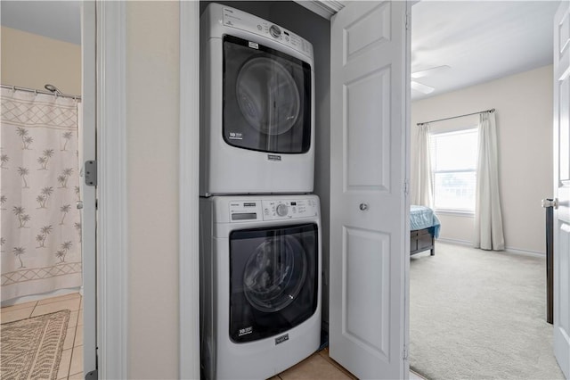 laundry area featuring stacked washer / dryer and light colored carpet