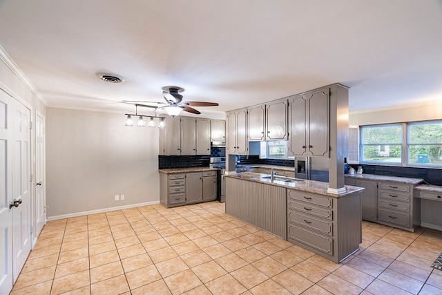 kitchen featuring light tile patterned flooring, sink, ornamental molding, tasteful backsplash, and gray cabinetry