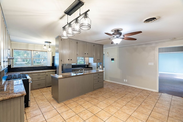 kitchen featuring gray cabinets, ceiling fan, stainless steel gas stove, and crown molding