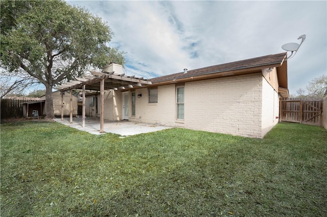 rear view of property with a pergola, a lawn, and a patio