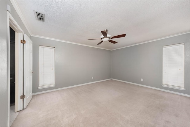 carpeted empty room featuring ornamental molding, ceiling fan, and a textured ceiling