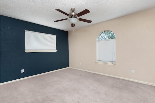 carpeted spare room with ceiling fan and a textured ceiling