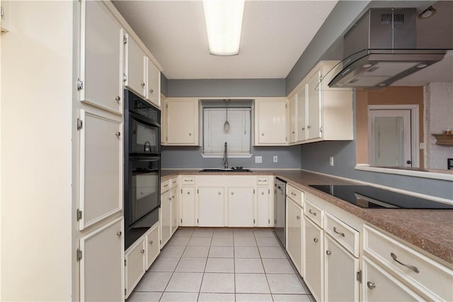 kitchen with sink, range hood, cream cabinets, black appliances, and light tile patterned flooring