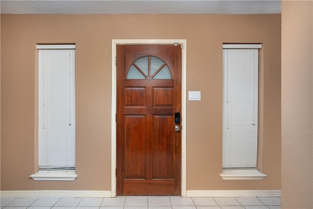 tiled entryway with a textured ceiling