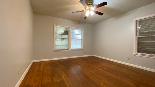 unfurnished room with ceiling fan and dark hardwood / wood-style flooring