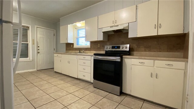 kitchen featuring sink, tasteful backsplash, light tile patterned floors, stainless steel electric range, and white cabinets