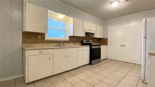 kitchen with stainless steel range with electric stovetop, light tile patterned flooring, white fridge, sink, and white cabinets