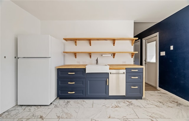 kitchen with blue cabinetry, sink, wooden counters, white refrigerator, and stainless steel dishwasher