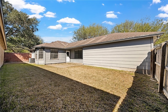 back of property featuring central AC and a lawn