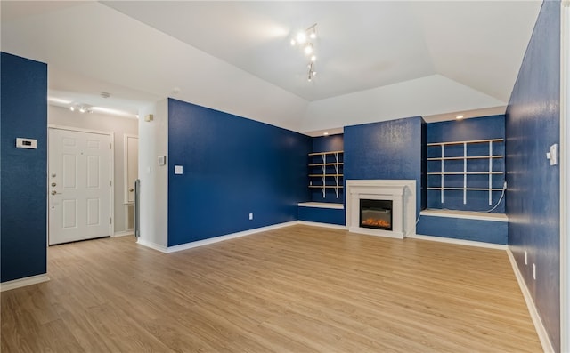 unfurnished living room featuring wood-type flooring and lofted ceiling