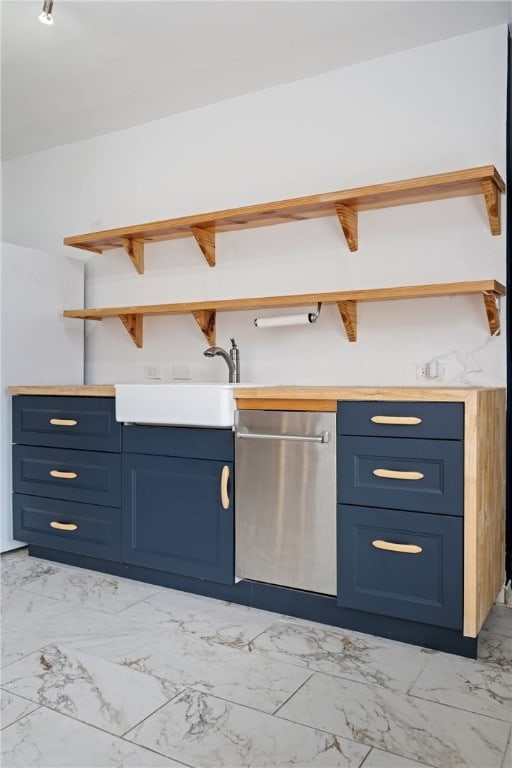 kitchen featuring sink, blue cabinetry, and stainless steel dishwasher