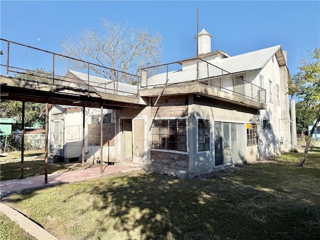 rear view of property featuring a lawn