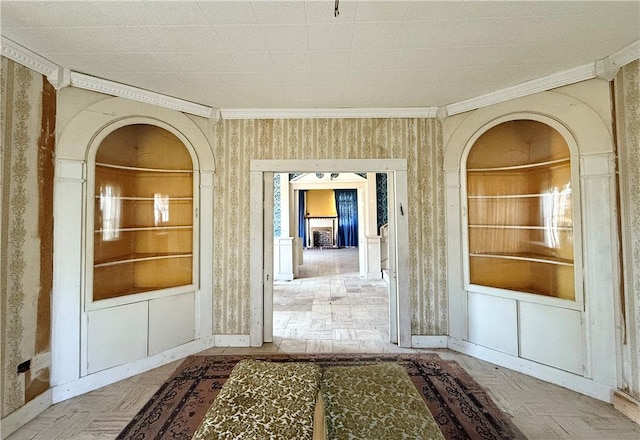 interior space with built in features, parquet floors, and ornamental molding