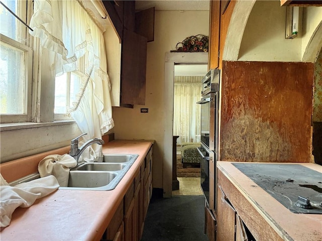 kitchen with black double oven and sink