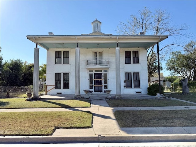 view of front facade with a balcony and a front lawn