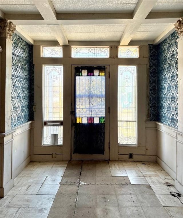 doorway to outside featuring beam ceiling and coffered ceiling