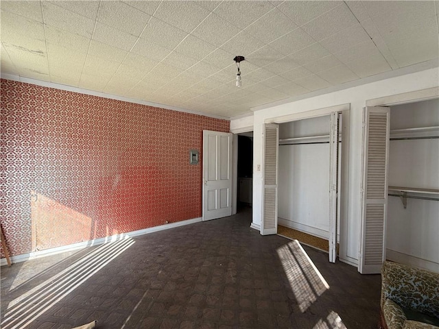 unfurnished bedroom featuring two closets and ornamental molding