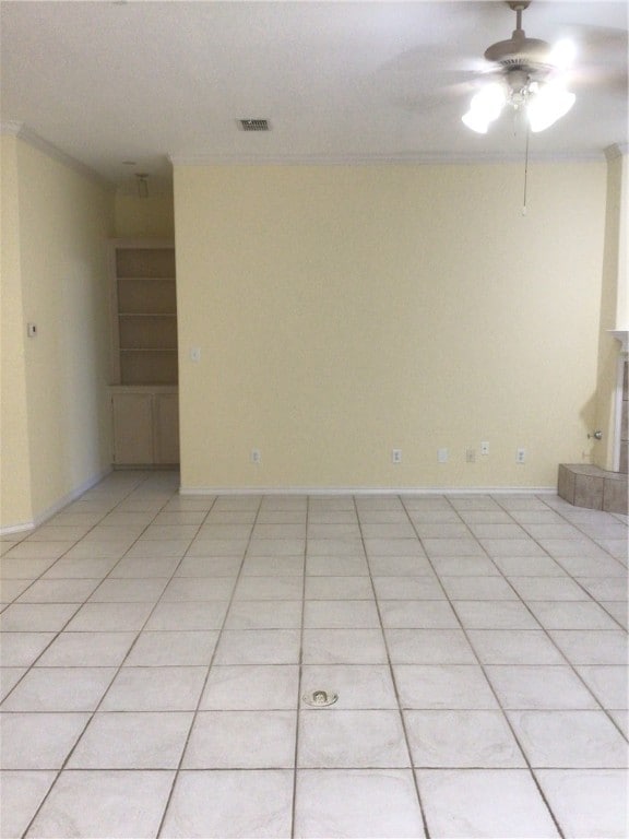 spare room with ceiling fan, light tile patterned floors, and ornamental molding