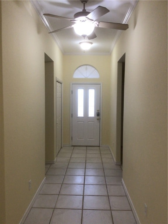 doorway with ceiling fan, light tile patterned floors, and crown molding