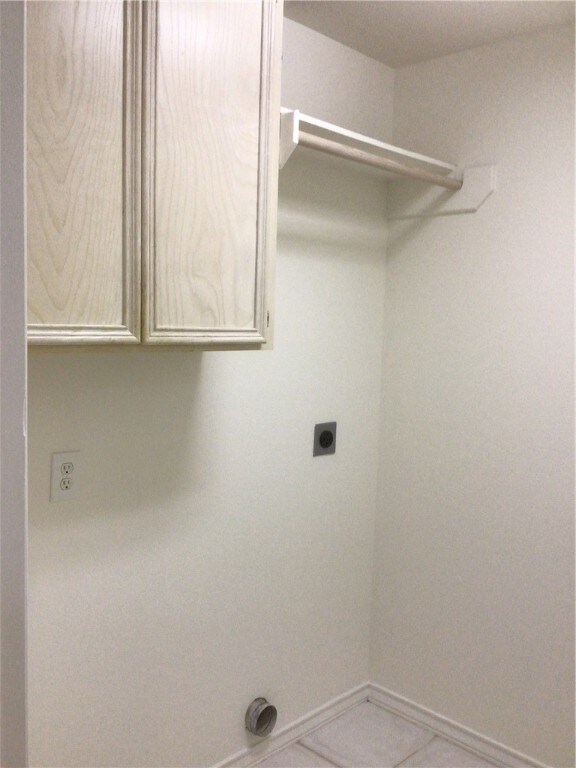 laundry room with cabinets, tile patterned flooring, and electric dryer hookup