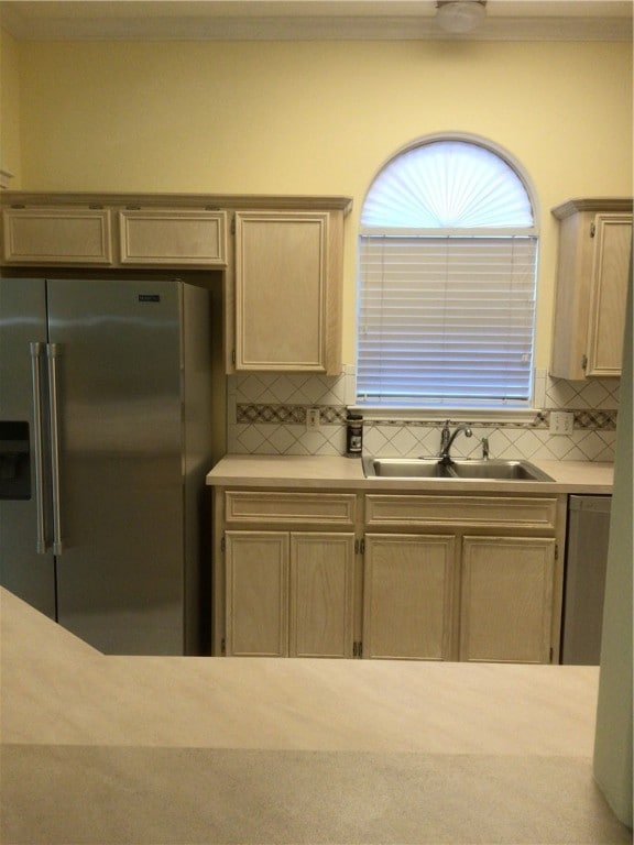 kitchen featuring light brown cabinetry, backsplash, appliances with stainless steel finishes, and sink