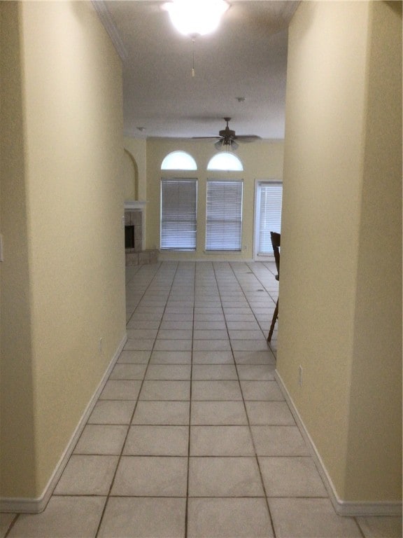 hall with light tile patterned floors and crown molding