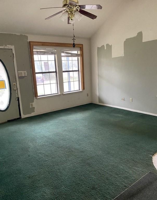 unfurnished room featuring baseboards, carpet flooring, a ceiling fan, and lofted ceiling