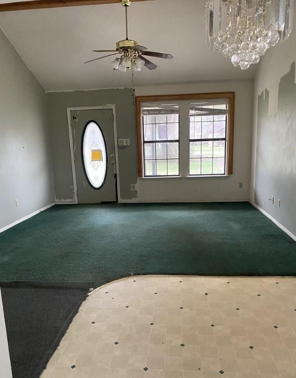 carpeted foyer featuring vaulted ceiling, a ceiling fan, and baseboards