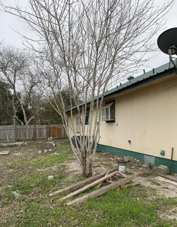 view of side of home featuring fence