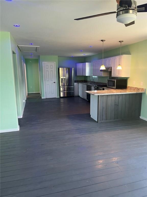 1123 S Fuqua St, Rockport, TX 78382 - kitchen with stainless steel appliances, a peninsula, baseboards, and dark wood-style flooring