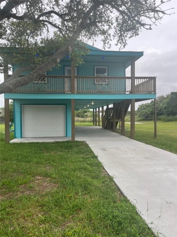 view of front of house with a carport, a front yard, concrete driveway, and an attached garage