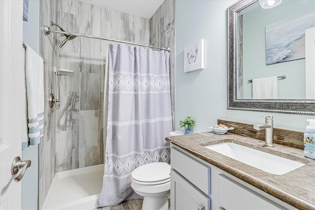 bathroom featuring a shower with shower curtain, vanity, and toilet