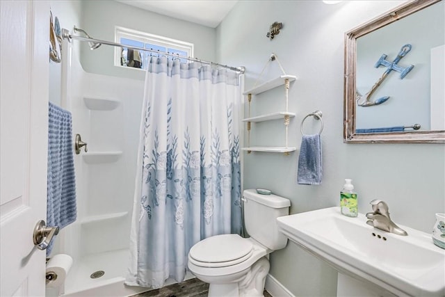 bathroom featuring hardwood / wood-style flooring, a shower with curtain, toilet, and sink