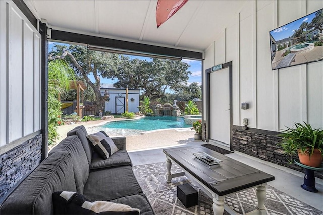 view of patio / terrace featuring a fenced in pool, outdoor lounge area, pool water feature, and a shed