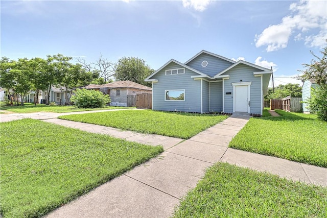 view of front facade with a front lawn and fence