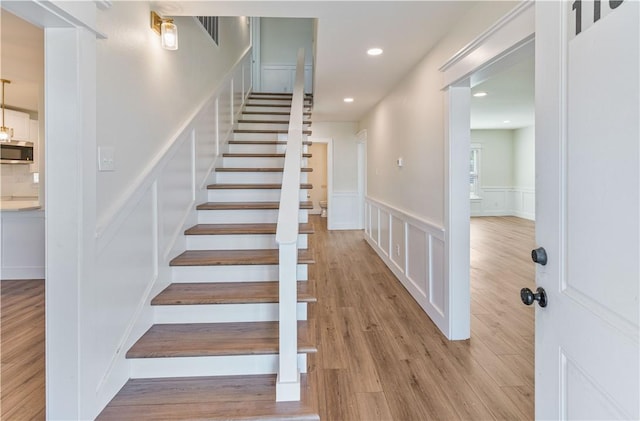 1101 6th St, Corpus Christi, TX 78404 - stairs with a decorative wall, wood finished floors, wainscoting, and recessed lighting