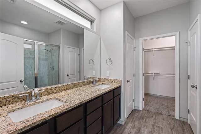 3406 Angelina St, Corpus Christi, TX 78414 - bathroom featuring a shower stall, double vanity, wood finished floors, a spacious closet, and recessed lighting