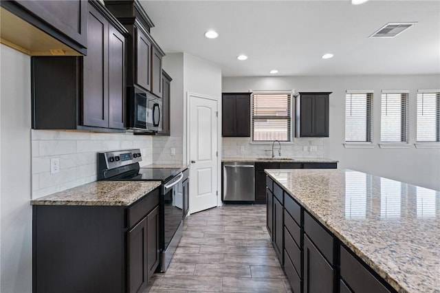 3406 Angelina St, Corpus Christi, TX 78414 - kitchen featuring appliances with stainless steel finishes, light stone countertops, recessed lighting, wood finished floors, and backsplash