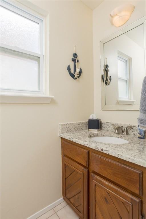 bathroom with vanity, baseboards, and tile patterned floors