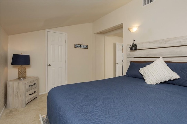 bedroom with light colored carpet, visible vents, and vaulted ceiling