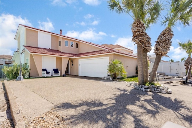 view of front of home with driveway, an attached garage, and stucco siding